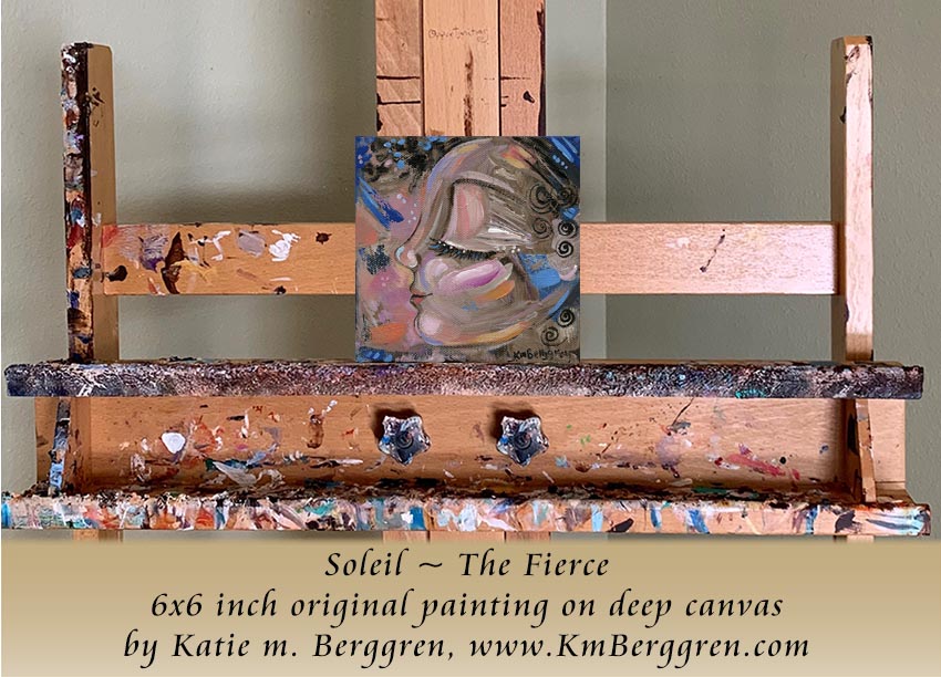 Olive-skinned woman's profile with blue and orange with black hair. Abstract artwork with text 'Soleil, The Fierce' and 'The Quiet Potential Collection' by KM Berggren. Artistic wooden easel with a painting titled 'Soleil ~ The Fierce' by Katie m. Berggren.