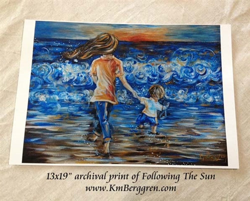 art print of mother walking towards the sun on the beach at the coast holding hands with a little boy walking with her